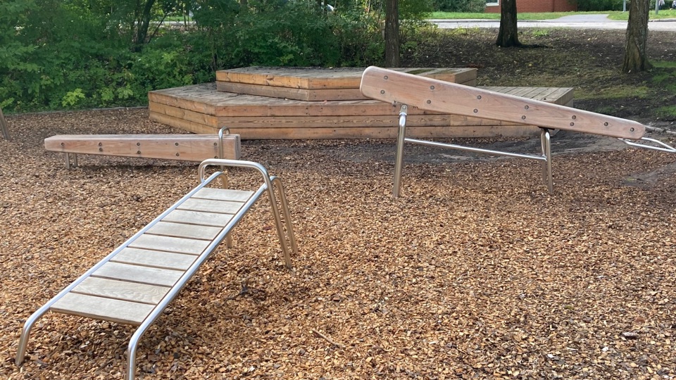 Träningsredskap i trä i ett utegym.