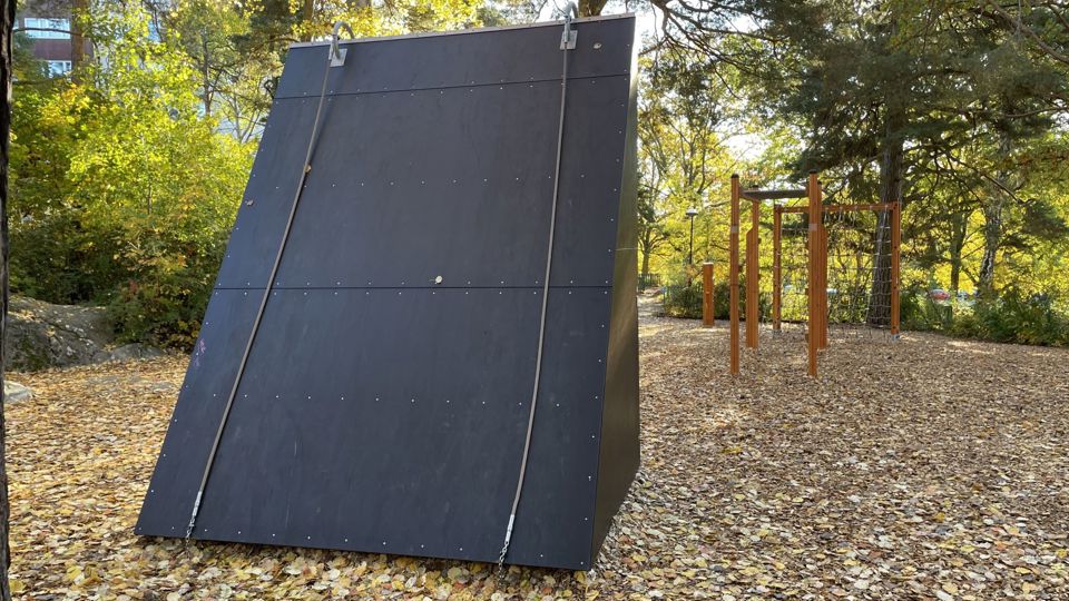 En hinderbana med ett stort hinder som består av en lutande vägg och två rep.