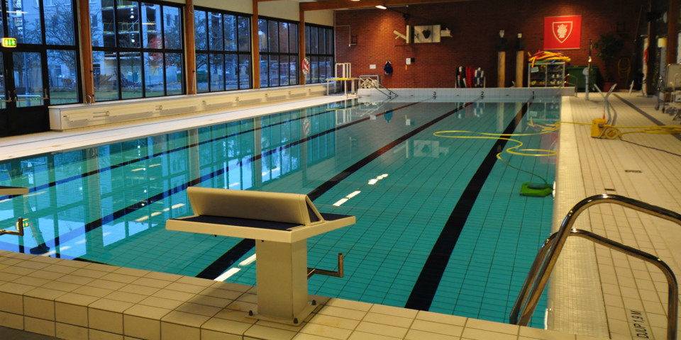 En interiörbild av Beckomberga simhall som visar en simbassäng.