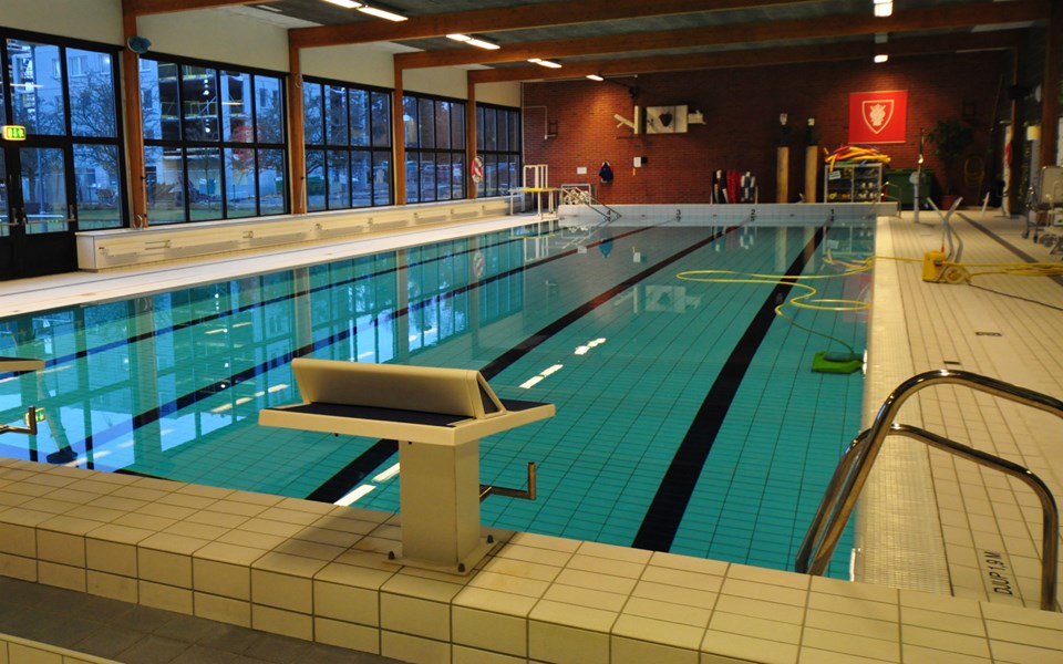 En interiörbild av Beckomberga simhall som visar en simbassäng.
