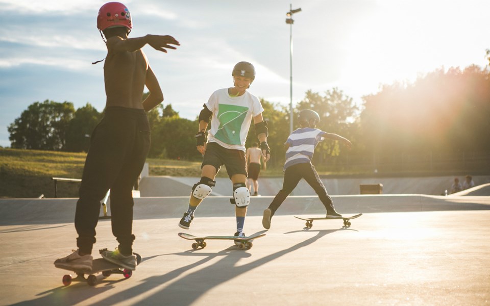 Några ungdomar som åker skateboard i en skatepark.