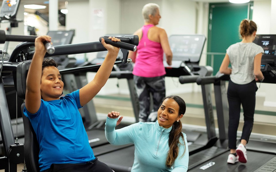 Unga och vuxna som tränar tillsammans i ett gym.