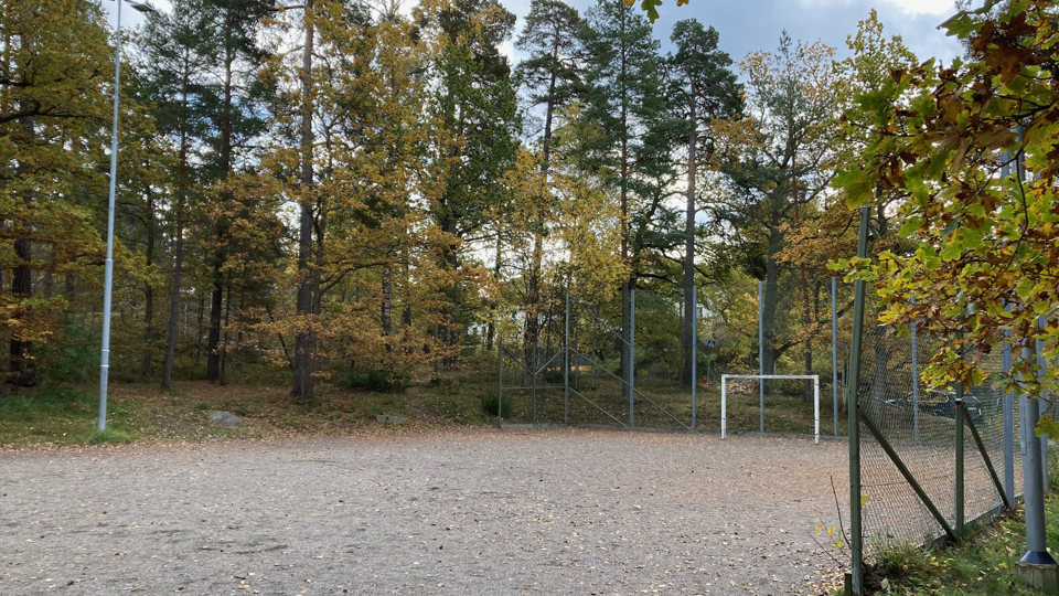 Bollplan i grus med staket runt planen.