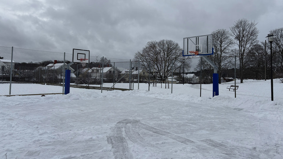 Snöig skridskobana med mörka moln ovanför, foto.