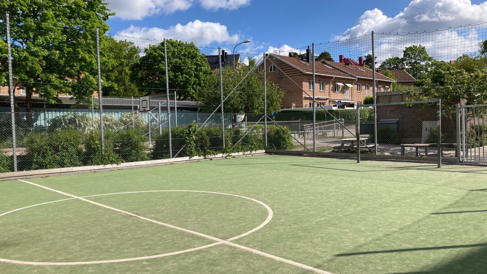 En bollplan omgärdad av ett högt stängsel.