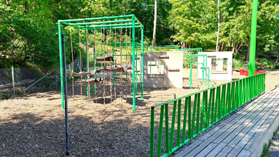 Parkourpark med gungor och staket.